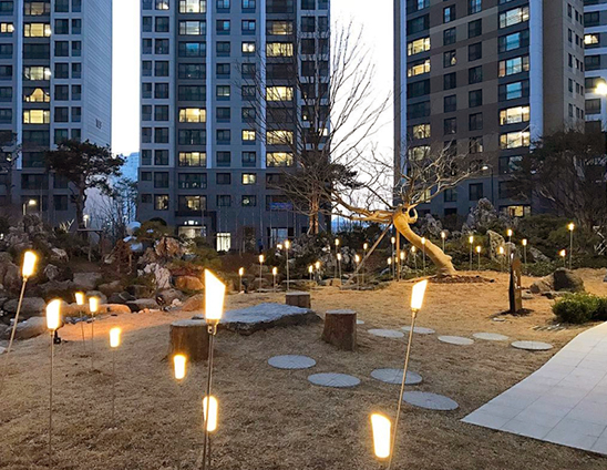 은은한 조명이 불을 밝힌 아파트 단지 가든의 저녁 풍경 - 자이브랜드매거진-비욘드아파트먼트-한강센트럴자이-봄산책5-1