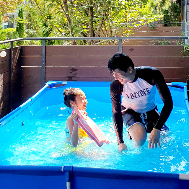 테라스에 작은 수영장을 설치해 물놀이를 즐기고 있는 아빠와 아이 - 청라파크자이더테라스-자이매거진-비욘드아파트먼트